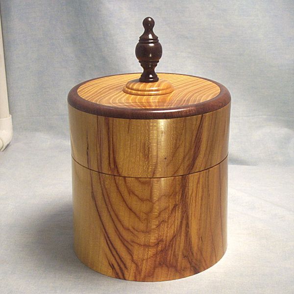 Osage Orange Box - 6 inch Diameter 019
View 1 - Osage Orange Turned Lidded Box with walnut rim on lid and walnut finial.  6 inch diameter, 6 1/4 inch tall without finial and 9 inches tall to top of finial. 
