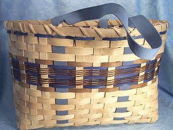 Donna's Tote Basket 003
Donna began weaving baskets 10 or 15 years ago and really enjoys it.  Her basket weaving skills amaze me and I love the creations she comes up with. I've loaded 4 different Tote  Baskets, each with a different color scheme.  A Tote Basket is used kind of like an attache case. You carry things in it whereever you go. Donna uses hers everyday and after years of use, it has that "worn" look, but still looks good.  
