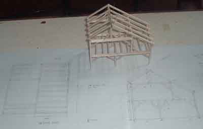 Photo of plans and model of a timber frame.
This photo shows the second floor plan and bent plan as well as the model.
