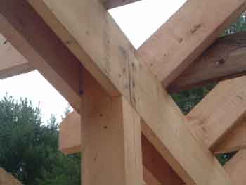 Photo showing notch in post for header to support rafters.
This photo is from a different pole barn but it shows another way to notch the pole to support the header used to support the horizontal plate attached to the top of the two vertical headers. This three sided box around the top of the pole make it very strong, in order to support the roof and the ceiling joists.
