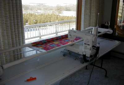 quilt_machine
Free-hand machine on carriage and tracks to get x-y positioning to 'stitch' fronts to backs with 'padding' in between. 
Keywords: Quilts