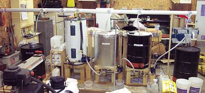 Bio-diesel processor
left to right - waste oil drum, methoxide stack, appleseed processor, standing tank, washing tank, drying tank.  The trunk above is for exhausting fumes to outside the shop.
Keywords: OWW bio-diesel