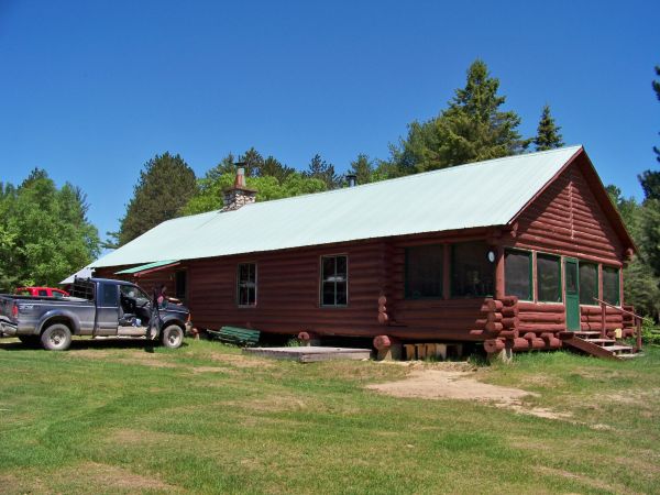 Kensington lodge Maniwaki Qc 
Front of this has a screened porch with table and chairs center part has double bunks good to sleep 20, we where 14. Back part is office, then kitchen then dinning room. Bunk house has one big fire place indoor washroom. 
