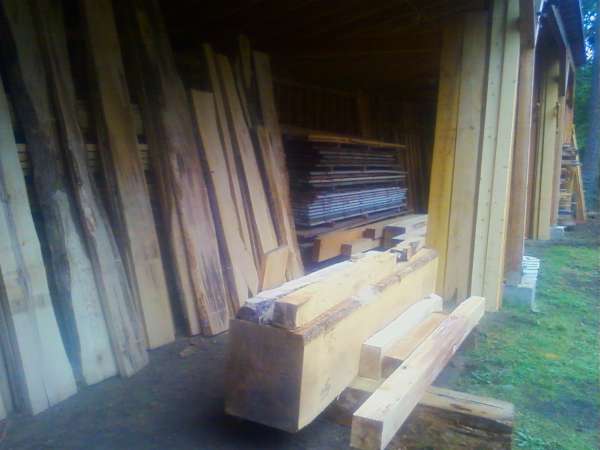 Drying shed 
displaying some cants of hardwoods with a 24" x 24" Doug fir cant
